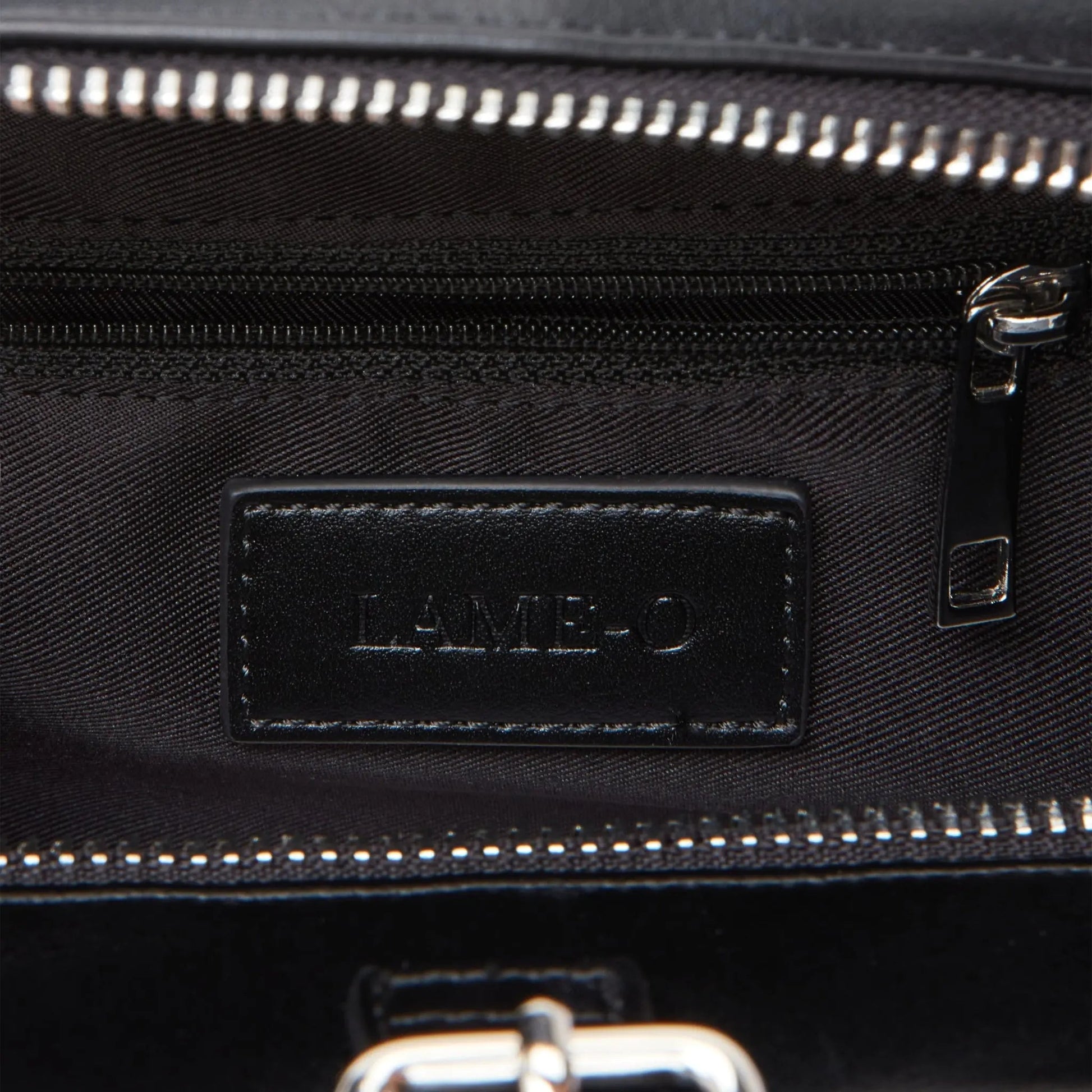 Interior of Lamoland trinket bag showing engraved logo above zipper pocket