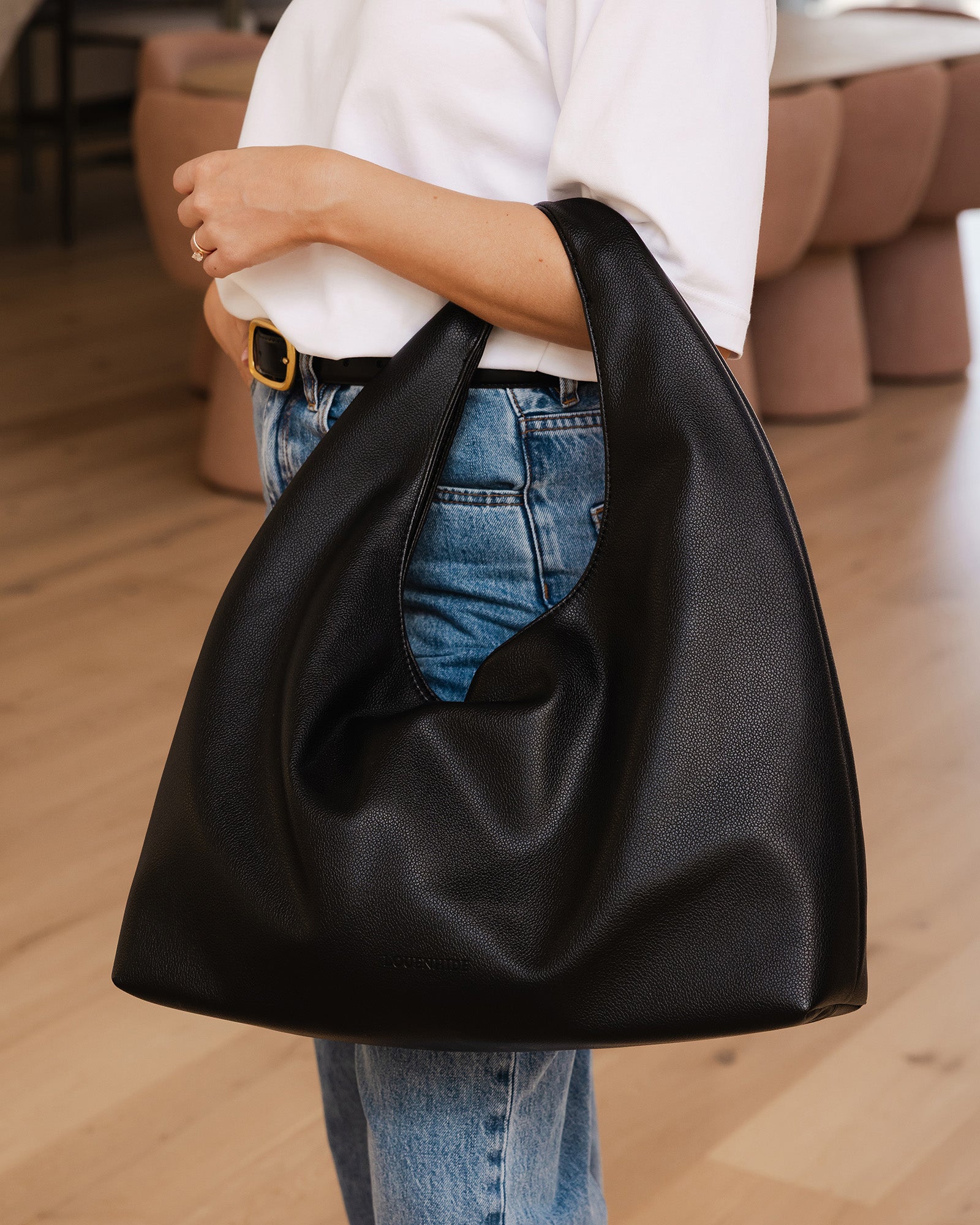 Louenhide Monaco Bag in black vegan leather paired with black belt and jeans